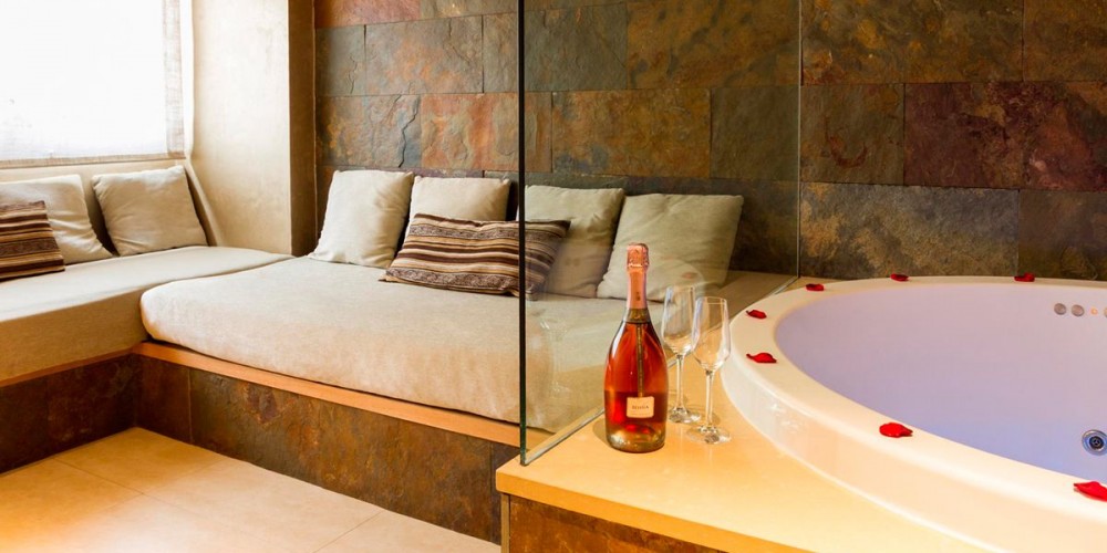 La Suite Romántica con Jacuzzi tiene dos ambientes separados por un baño-vestidor. El sofá es convertible en dos camas, y dispone de un gran jacuzzi de 1,60m con cromoterapia. Trato especial para novios.