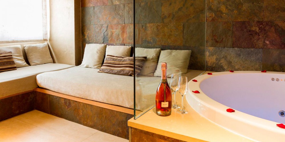 The Romantic Suite with jacuzzi has two areas separated by a bathroom-dressing room. In the living area there is an L-shaped sofa, TV and a large 1.60-metre Jacuzzi with chromotherapy.